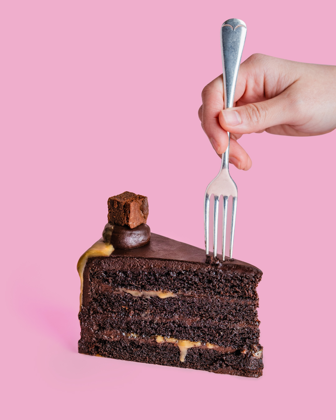 fork going into chocolate cake slice