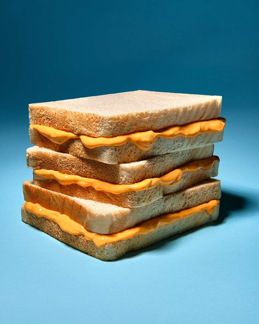 three cheez whiz filled sandwiches in a stack