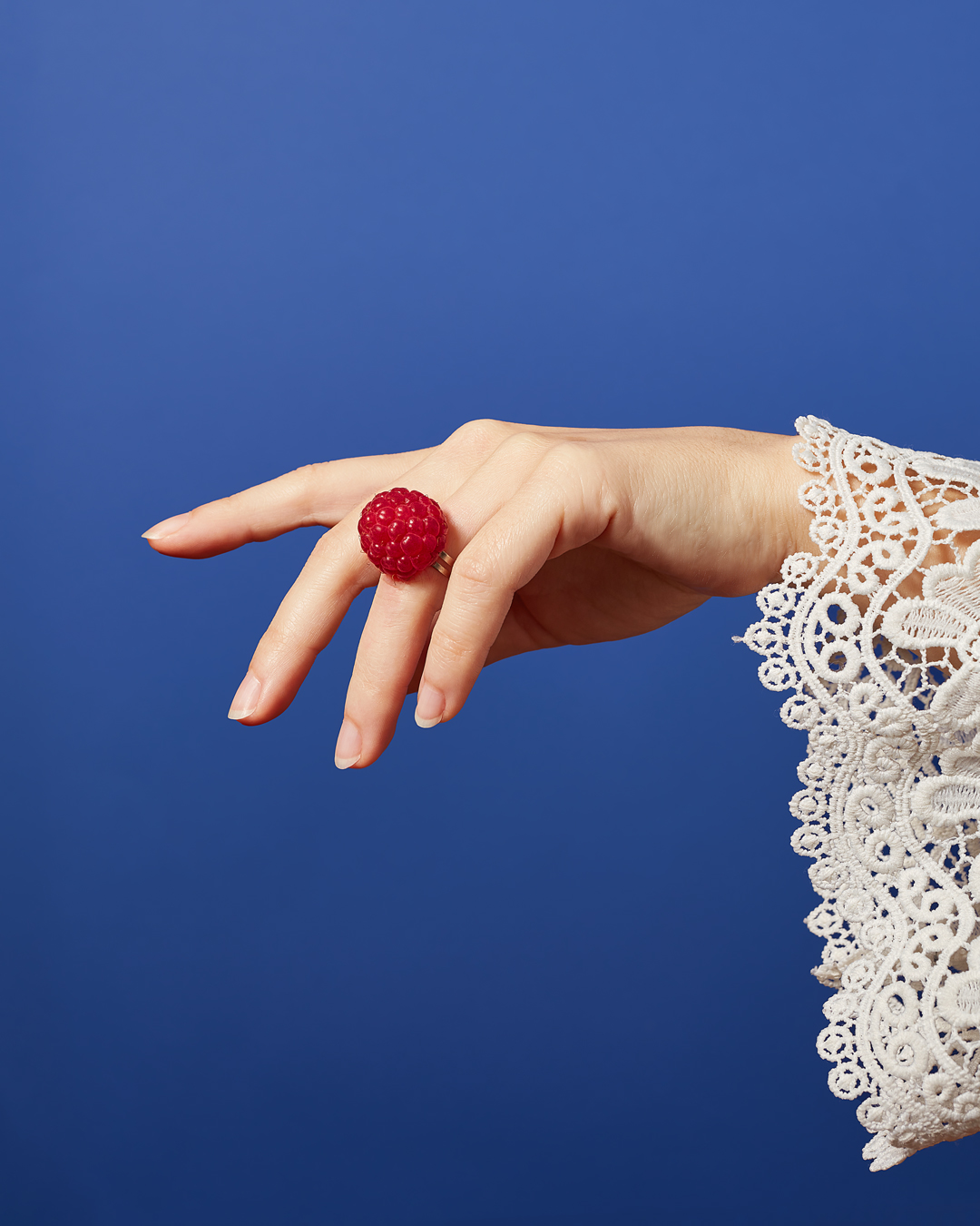 raspberry ring on woman's finger